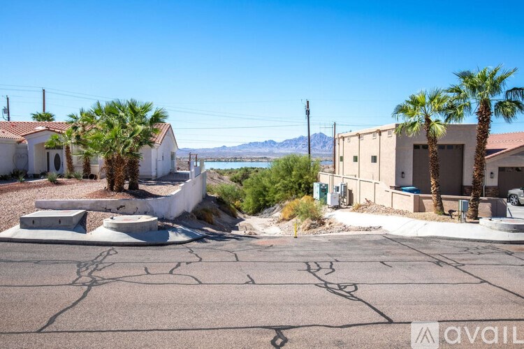A sunny day in a residential area with houses and palm trees.