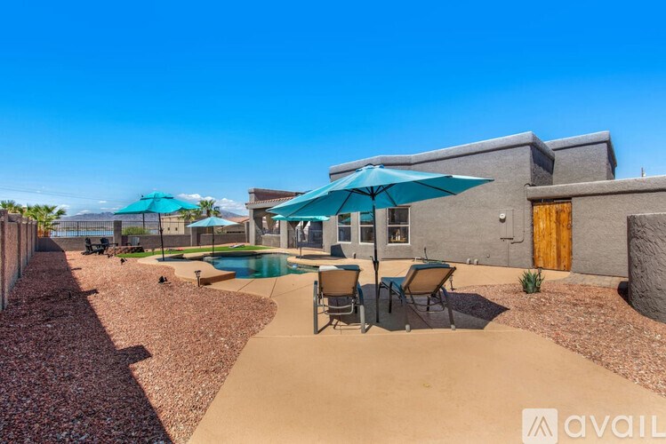 A sunny day at the outdoor pool area with chairs and umbrellas.