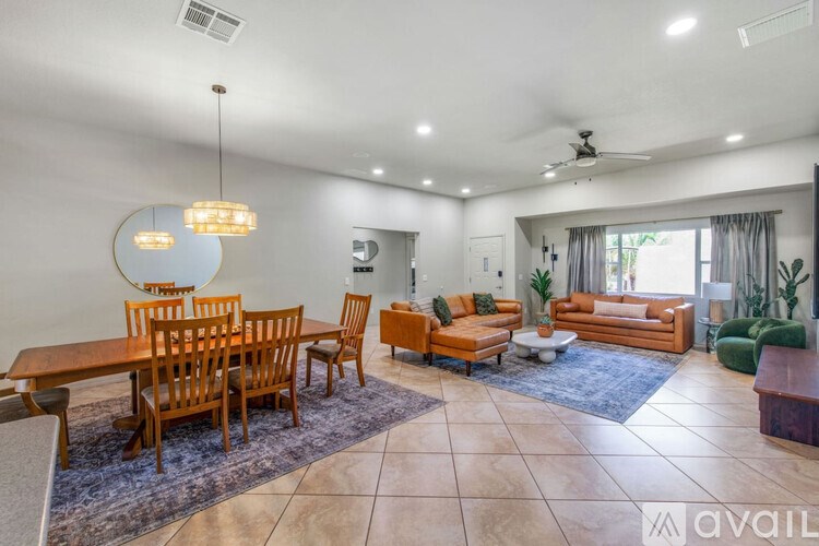 A well-lit living room with a dining table and chairs.