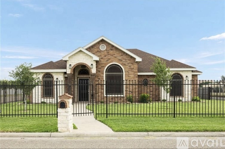 A house with a black fence and a brick facade.