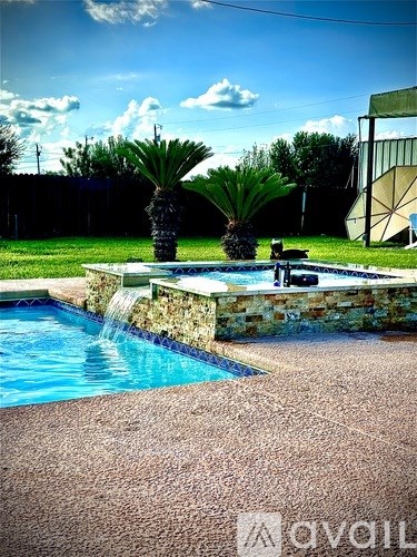 A pool with a waterfall and a palm tree in the background.
