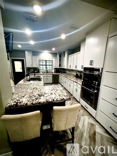 A kitchen with a granite countertop and white cabinets.
