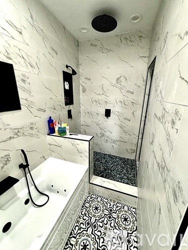 A white bathroom with a black and white tiled floor.
