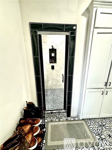 A pair of brown shoes are on the floor by a door.