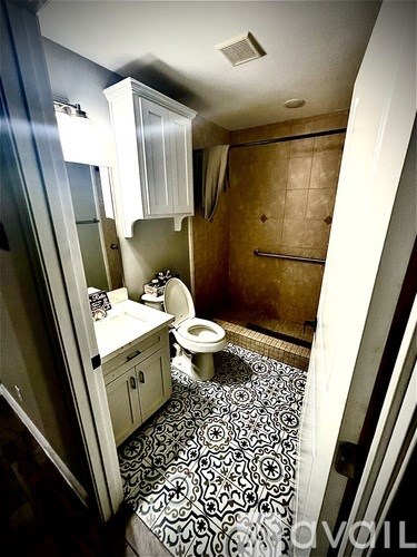 A bathroom with a toilet, sink, and a mirror.