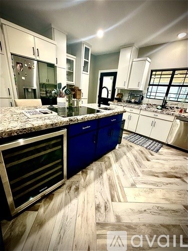 A kitchen with a granite countertop and blue cabinets.