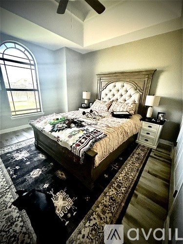 A bedroom with a large bed and a window.