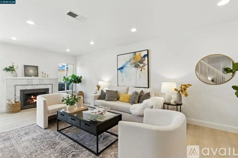 A modern living room with a fireplace and a painting on the wall.
