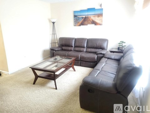 A living room with a grey leather couch and a wooden coffee table.