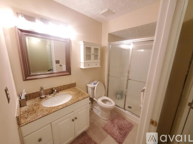 A bathroom with a sink, toilet, and mirror.