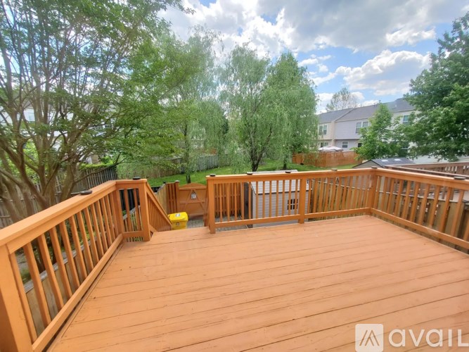 A wooden deck with a railing and a yellow bucket on it.