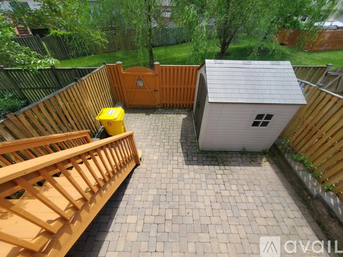 A backyard with a wooden deck and a shed.