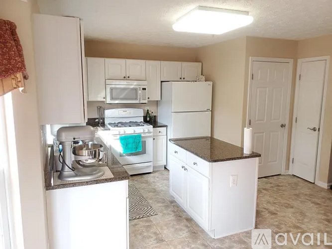 A kitchen with white appliances and cabinets.