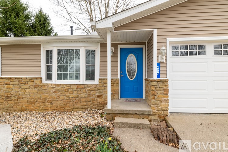 A house with a blue door and a white garage door.