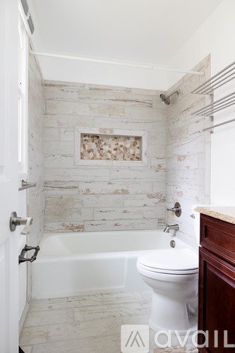 A bathroom with a white toilet and a white bathtub.
