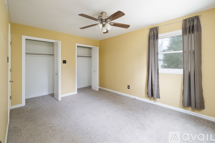 A room with a ceiling fan and two doors.