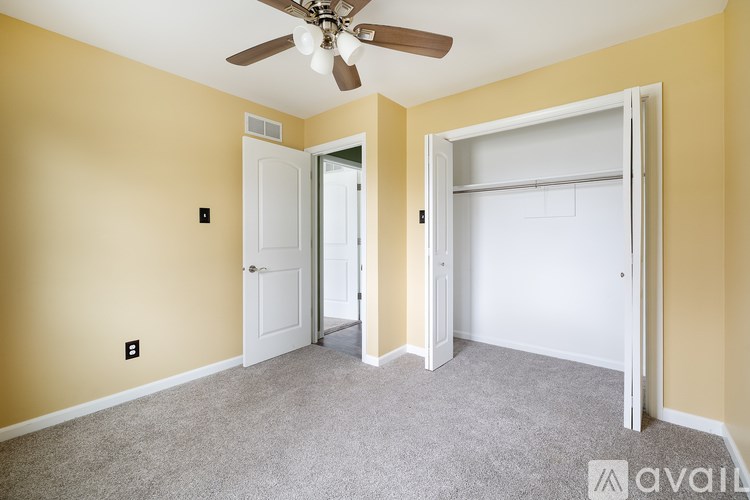 A room with a ceiling fan and two doors.