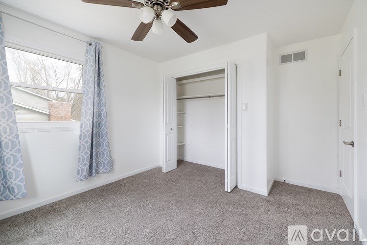 A room with a ceiling fan and a sliding door.