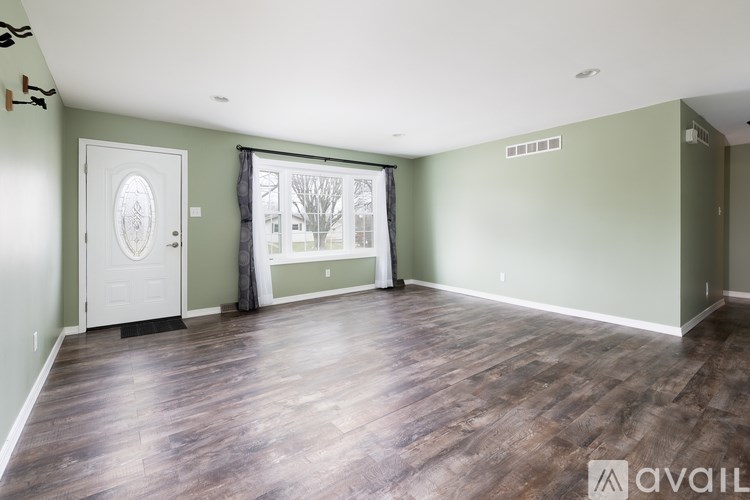 A room with wood flooring and a white door.