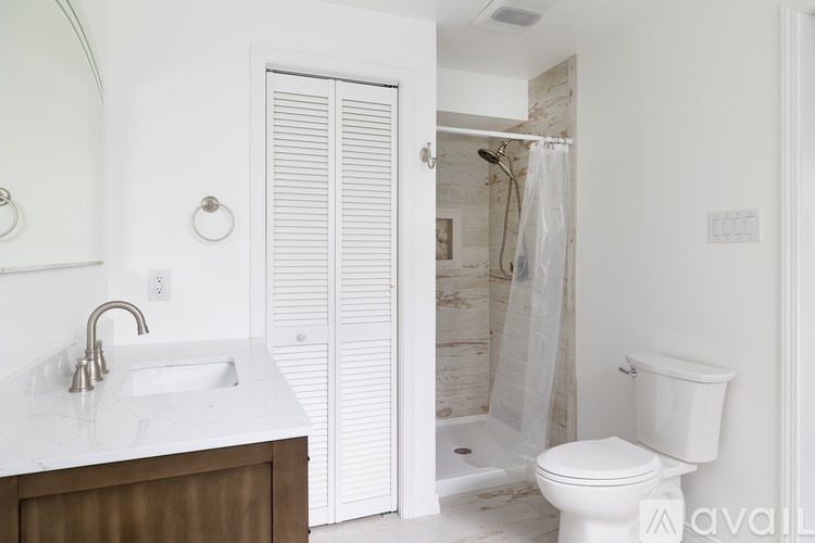 A white bathroom with a sink, toilet and shower.