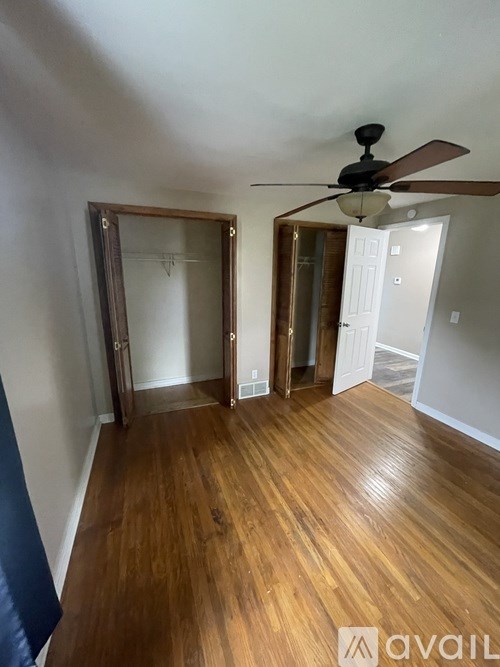 A room with wooden floors and a ceiling fan.