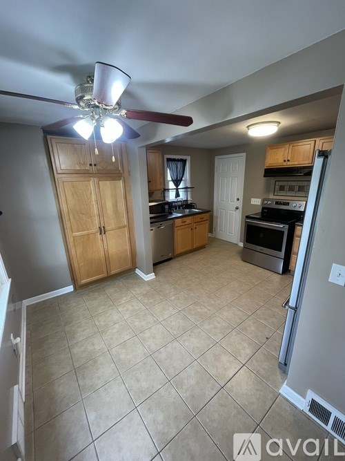 A kitchen with a refrigerator, oven, and cabinets.