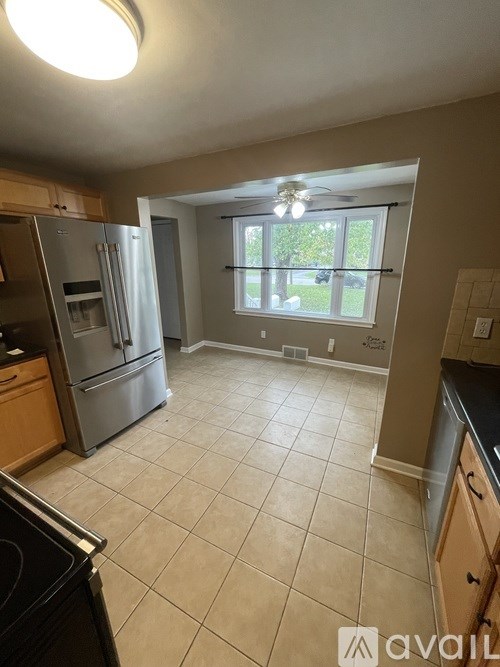 A kitchen with tile flooring and a large window.