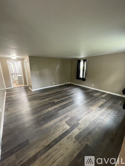 A room with wooden flooring and a window.