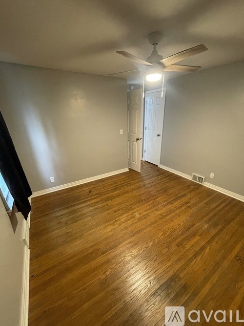 A room with wooden flooring and a ceiling fan.