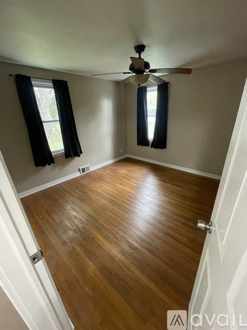 A room with wooden floors and a ceiling fan.