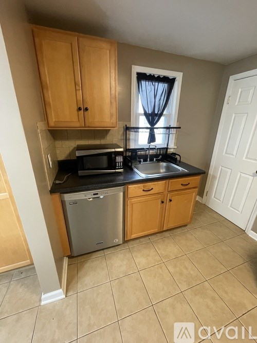 A kitchen with wooden cabinets and a black countertop.