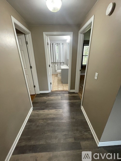 A hallway with a light on and a door on the left.