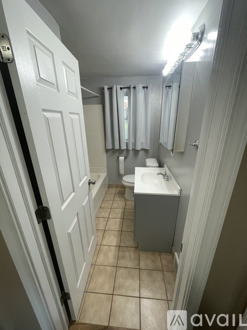 A bathroom with a toilet, sink, and shower.