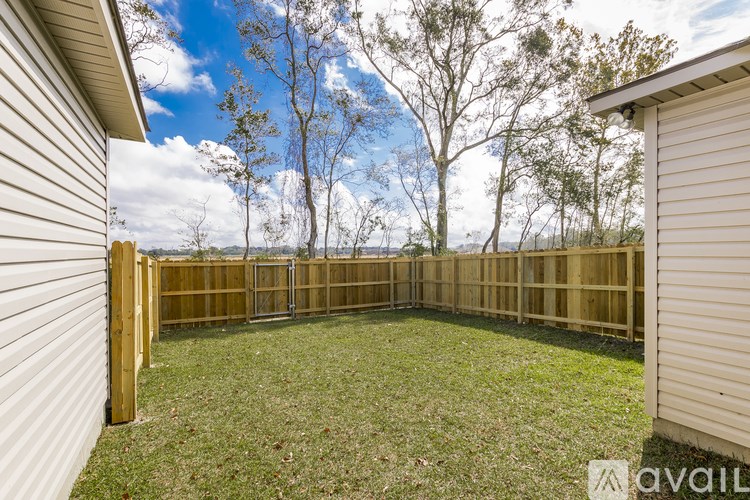 A backyard with a wooden fence and a grassy area.
