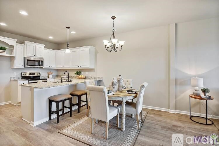 A well-lit kitchen with a dining table set for two.