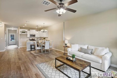 A living room with a white couch and a wooden coffee table.