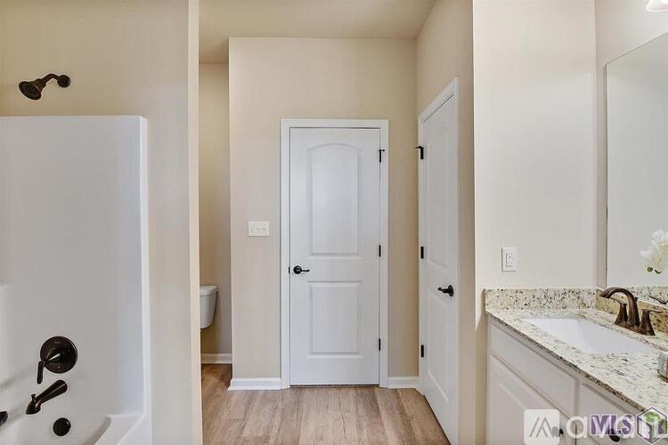 A white door is in the middle of a bathroom.