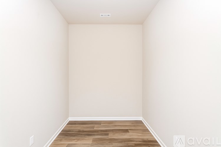 A room with wooden flooring and white walls.