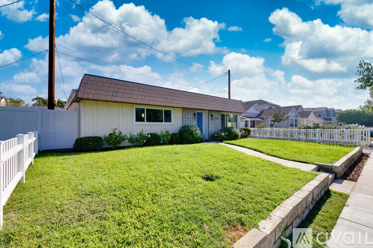 A house with a white picket fence in front.