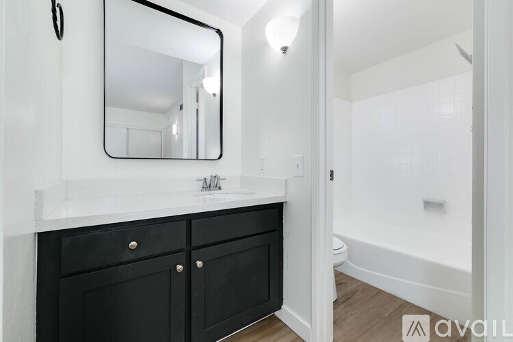 A bathroom with a white countertop and black cabinets.