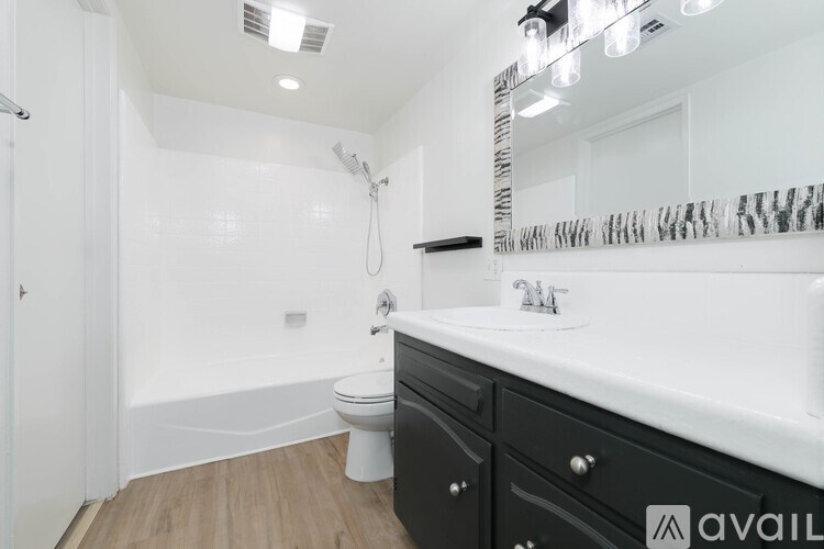A bathroom with a white sink and a white toilet.