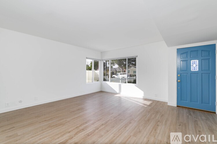 A room with a blue door and wooden flooring.