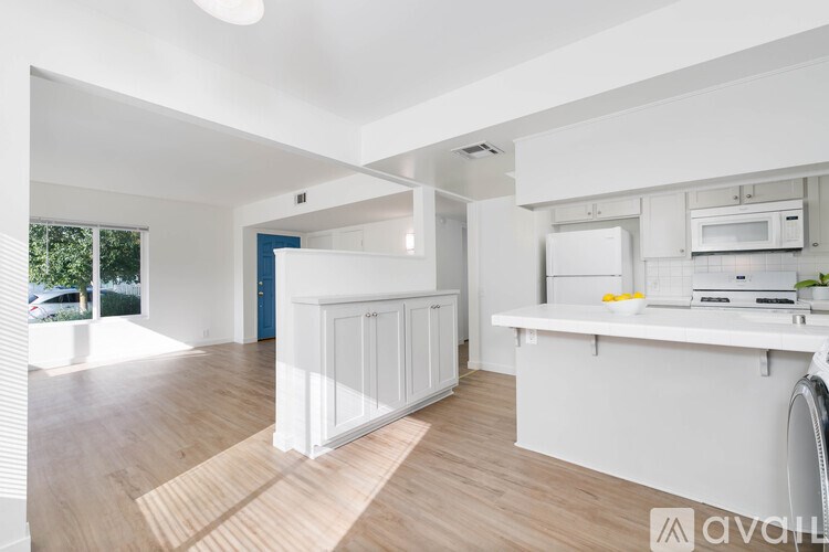 A kitchen with white cabinets and a white countertop.