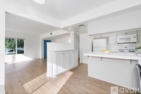 A kitchen with white cabinets and a white countertop.