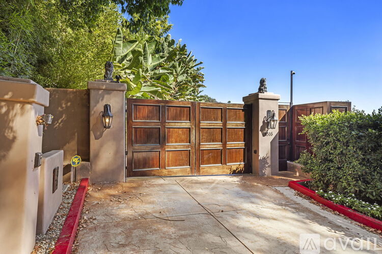 A gated entrance to a property with a red curb.