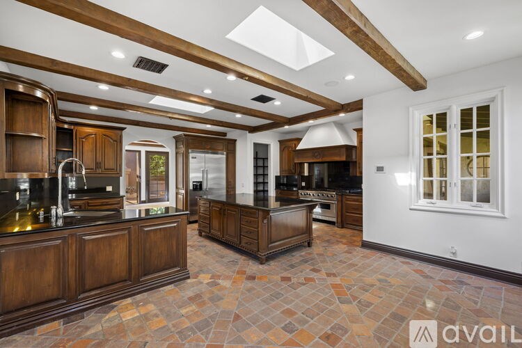 A kitchen with wooden cabinets and a tiled floor.