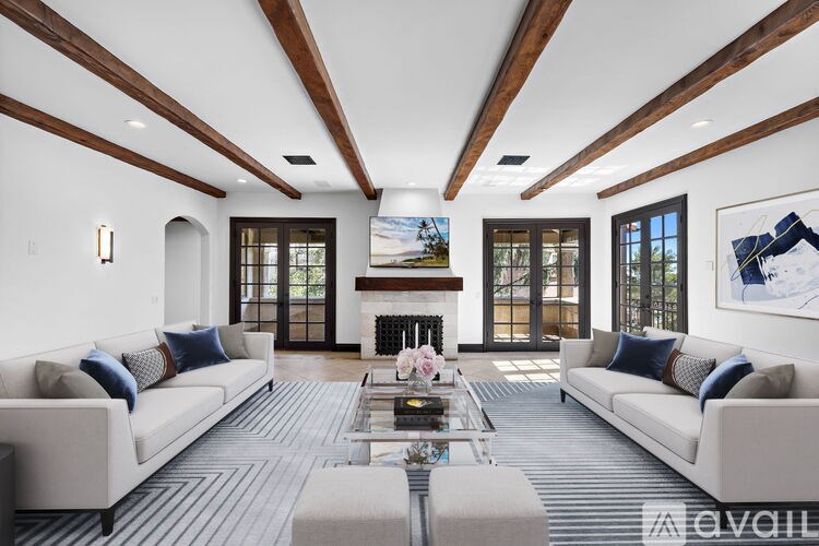 A spacious room with a white ceiling and wooden beams.