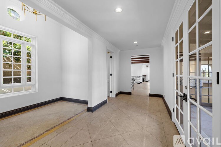 A spacious room with a tiled floor and a large window.