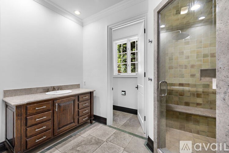 A bathroom with a sink, a mirror, and a shower.