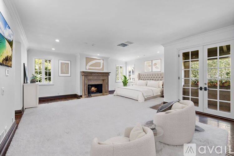 A spacious room with a fireplace and wooden floors.